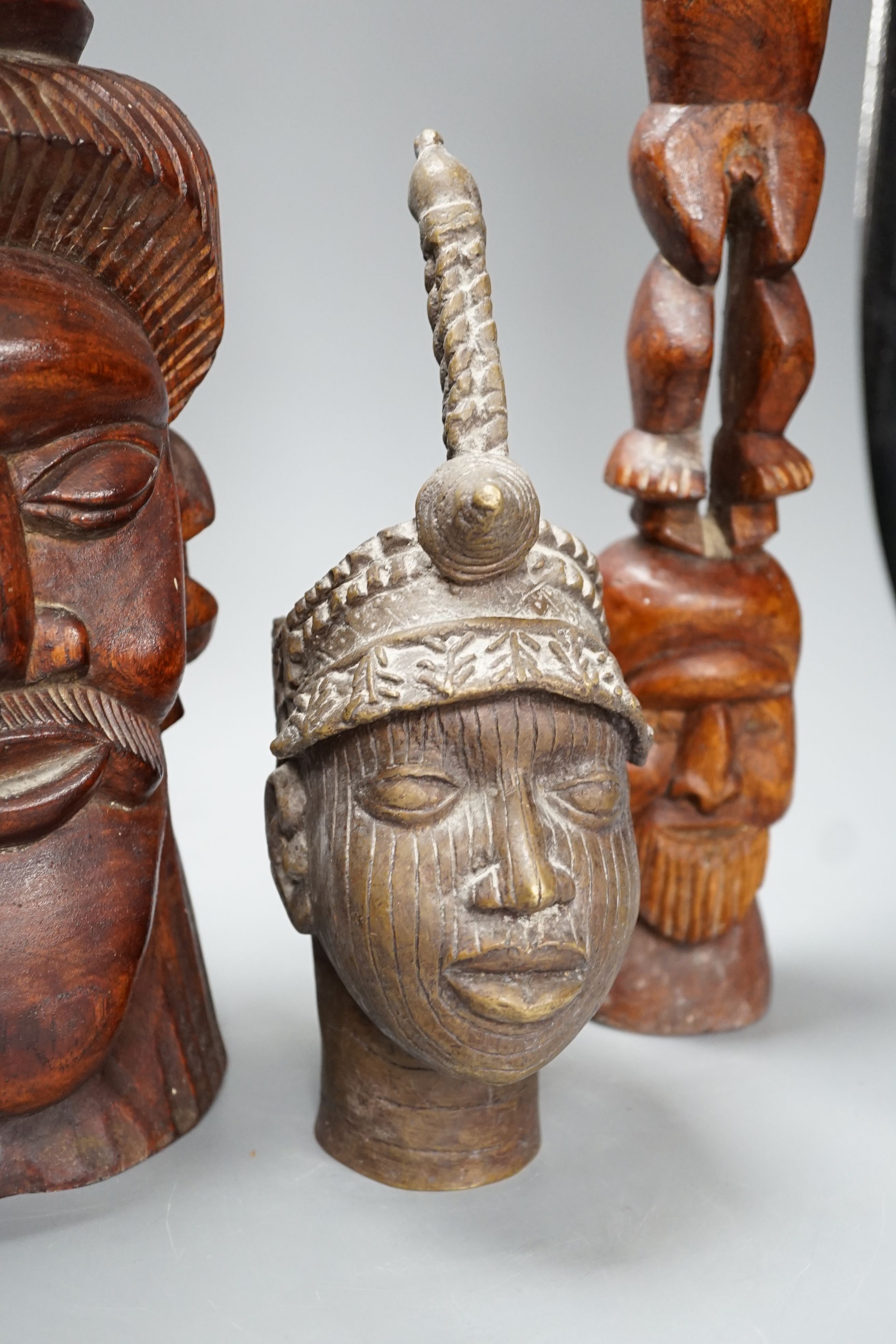 A metal Benin style bust, a carved tribal bust and another